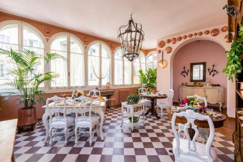 comedor con mesa, sillas y ventanas en FORESTERIA di PALAZZO RADICI, en Bérgamo