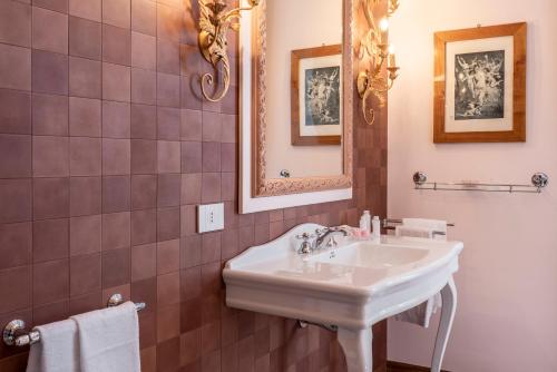 a bathroom with a white sink and a mirror at FORESTERIA di PALAZZO RADICI in Bergamo