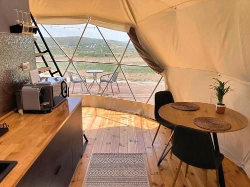 Zelt mit Tisch und Stühlen in einem Zimmer mit Fenster in der Unterkunft Baladome in Dörgicse