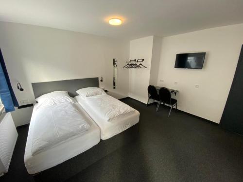 um quarto de hotel com duas camas e uma secretária em Zzzimple - Staffless & Self Check-In em Pillig