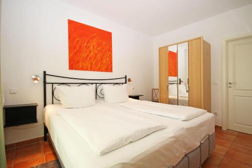 キュールングスボルンにあるAm-Yachthafen-Villa-Hiddensee-11-500のベッドルーム(白いシーツを使用した大型ベッド1台付)
