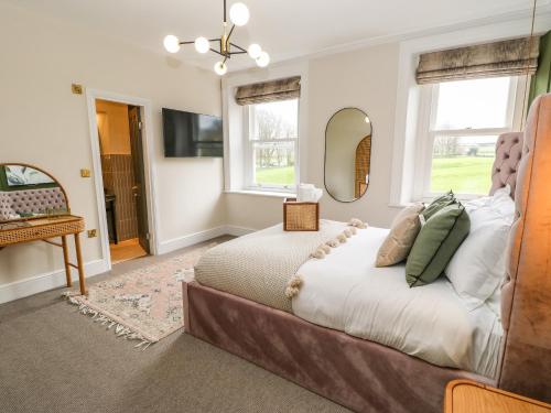 a bedroom with a large bed and a mirror at Hillside House in Leyburn