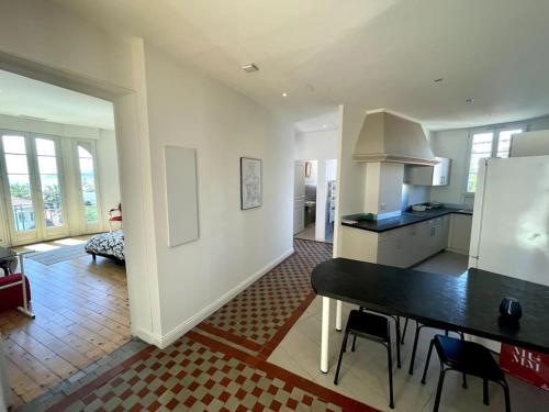 une cuisine et un salon avec une table et des chaises dans l'établissement SUPERBE 2 TERRASSES VUE MER, à Cannes