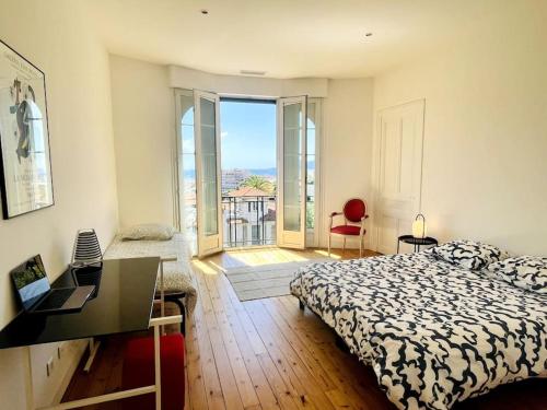 une chambre avec un lit et une vue sur un balcon dans l'établissement SUPERBE 2 TERRASSES VUE MER, à Cannes