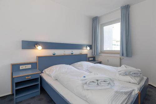 a bedroom with a bed with white sheets and towels at Yachthafenresidenz-Wohnung-5203-812 in Kühlungsborn
