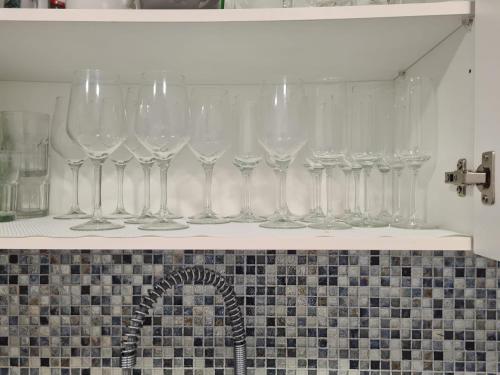 a row of wine glasses on a shelf above a sink at BRISA MAR in Póvoa de Varzim