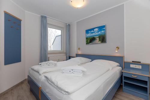 キュールングスボルンにあるYachthafenresidenz-Wohnung-5304-816のベッドルーム1室(ベッド1台、タオル2枚付)