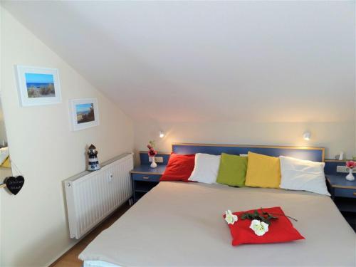 ein Schlafzimmer mit einem Bett mit bunten Kissen in der Unterkunft Yachthafenresidenz - Wohnung 5306 / 817 in Kühlungsborn