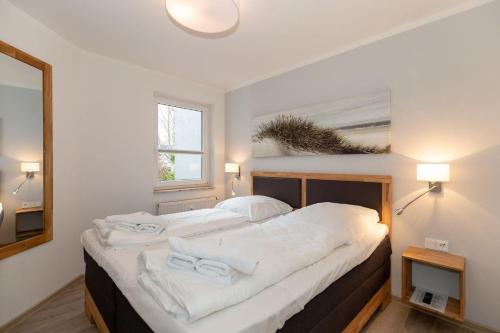 a bedroom with a bed with white towels on it at Yachthafenresidenz-Wohnung-5104-808 in Kühlungsborn