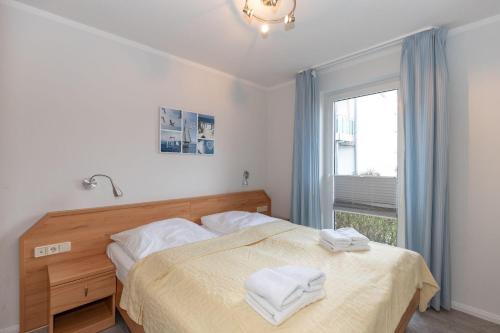 een slaapkamer met een bed met twee handdoeken erop bij Yachthafenresidenz-Wohnung-6101-818 in Kühlungsborn