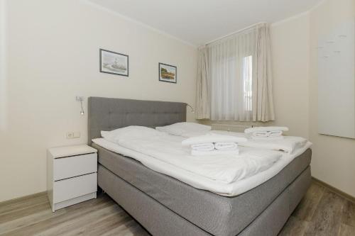 a bedroom with a large bed with white sheets at Yachthafenresidenz-Wohnung-6103-822 in Kühlungsborn