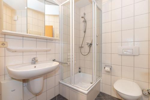 a bathroom with a shower and a sink and a toilet at Yachthafenresidenz-Wohnung-6103-822 in Kühlungsborn
