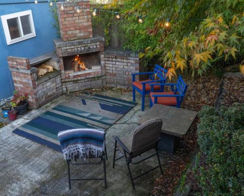 a patio with a fireplace with chairs and a table at Greenwood Mother in Law in Seattle