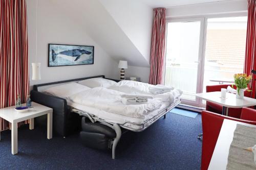 キュールングスボルンにあるYachthafenresidenz - Wohnung 6302 / 835のベッドルーム1室(ベッド1台、テーブル、窓付)