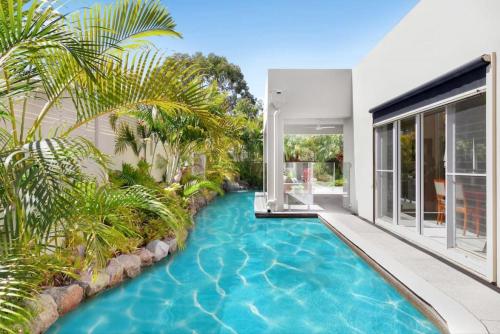 an infinity pool in the backyard of a house at Luxury resort style villa pool by Custom Bnb Hosting in Pelican Waters