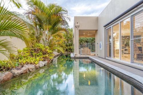 a house with a swimming pool next to a house at Luxury resort style villa pool by Custom Bnb Hosting in Pelican Waters