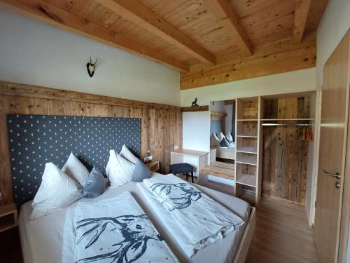a bedroom with a large bed with a wooden ceiling at Apart Lechtraum in Stanzach