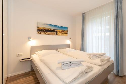 キュールングスボルンにあるYachthafenresidenz-Wohnung-7101-837のベッドルーム1室(ベッド2台、タオル付)