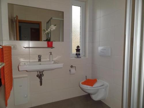 uma casa de banho branca com um lavatório e um WC em Yachthafenresidenz-Wohnung-8109-847 em Kühlungsborn