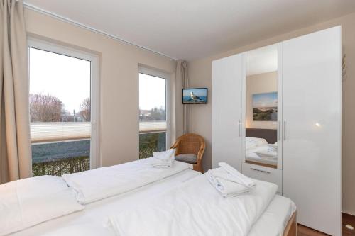 two beds in a room with a large window at Yachthafenresidenz-Wohnung-8111-849 in Kühlungsborn