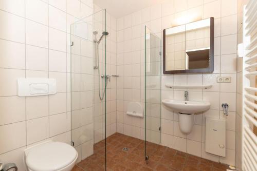 a bathroom with a toilet and a sink and a shower at Yachthafenresidenz-Wohnung-8111-849 in Kühlungsborn