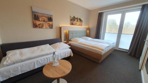 a hotel room with two beds and a table at Hotel An der Altstadt in Hameln
