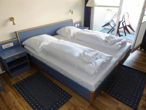 キュールングスボルンにあるYachthafenresidenz-Wohnung-8205-853のベッド(白いシーツ、枕付)
