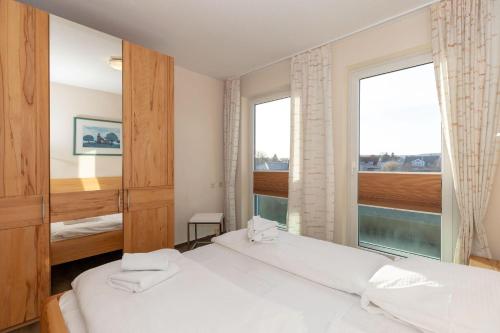 a bedroom with two beds and a large window at Yachthafenresidenz-Wohnung-8212-855 in Kühlungsborn