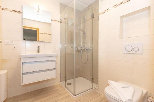 a bathroom with a shower and a toilet and a sink at Yachthafenresidenz-Wohnung-8212-855 in Kühlungsborn