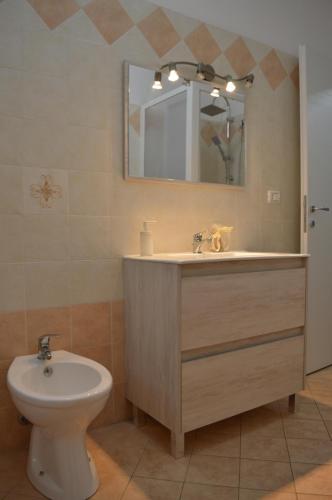 a bathroom with a sink and a toilet and a mirror at Casa vacanza Nicuzza in Castellammare del Golfo