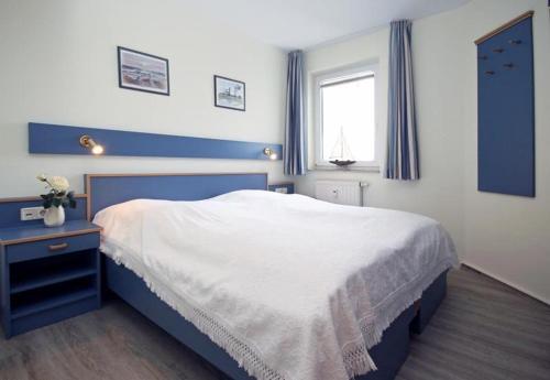 a blue and white bedroom with a bed and a window at Yachthafenresidenz-Wohnung-8303-859 in Kühlungsborn