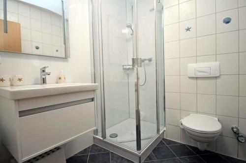 a bathroom with a shower and a toilet and a sink at Yachthafenresidenz-Wohnung-8303-859 in Kühlungsborn