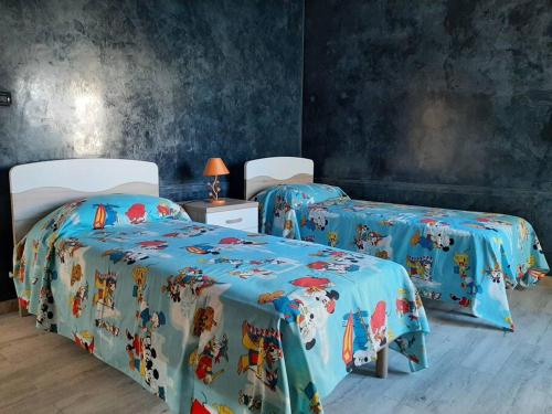 two twin beds in a room with blue walls at Casa Vacanza 30 in Galatina