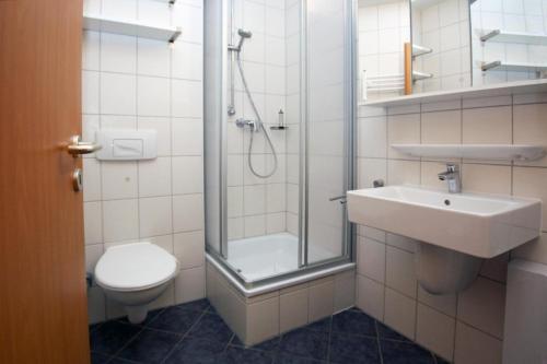 a bathroom with a shower and a toilet and a sink at Yachthafenresidenz-Wohnung-8308-863 in Kühlungsborn