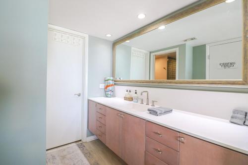 La salle de bains est pourvue d'un lavabo et d'un grand miroir. dans l'établissement Windjammer 213, à Saint Augustine