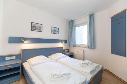 a bedroom with a bed with white sheets and a window at Yachthafenresidenz-Wohnung-8307-862 in Kühlungsborn