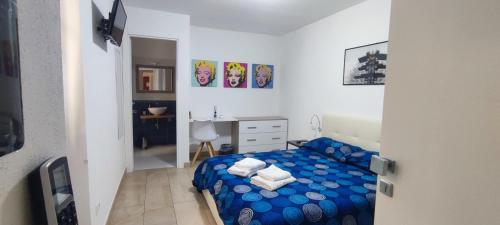 um quarto com uma cama azul e uma secretária em Archubintu B&B your friendly place em Sassari
