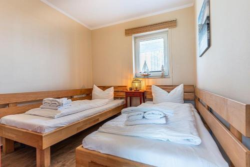 two twin beds in a room with a window at Yachthafenresidenz-Wohnung-9101-877 in Kühlungsborn