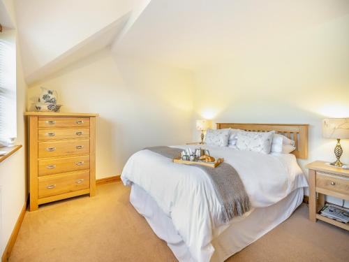 a bedroom with a large white bed and a dresser at Pennant in Llangurig