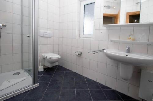 a bathroom with a toilet and a sink and a shower at Yachthafenresidenz-Wohnung-9106-881 in Kühlungsborn