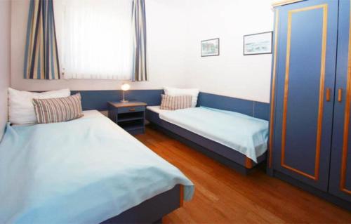キュールングスボルンにあるYachthafenresidenz-Wohnung-9109-883のベッド2台と窓が備わる小さな客室です。