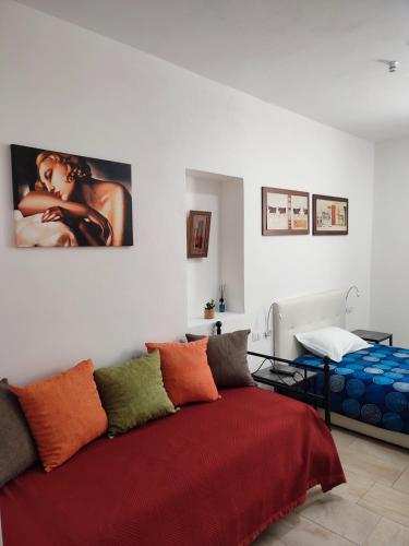 a bedroom with a bed with a red blanket at Archubintu B&B in Sassari