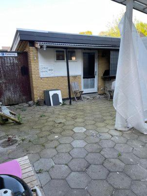 a house with a patio with a white umbrella at Rundvejen Guest House in Aalborg