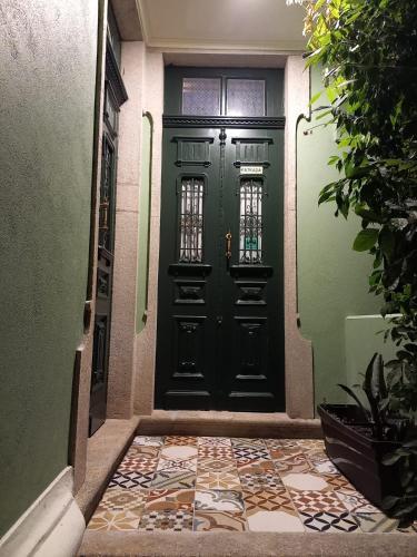 a green door with a tile floor in front of it at Casa Vila Palmeira in Fermelã