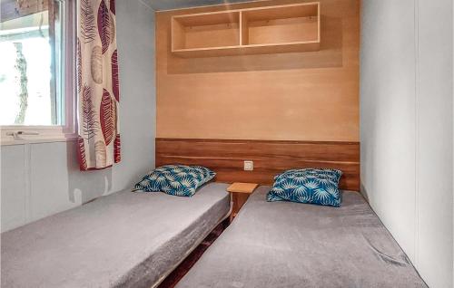 a small room with two beds and a window at Awesome stacaravan In Saint-georges-de-didon in Saint-Georges-de-Didonne