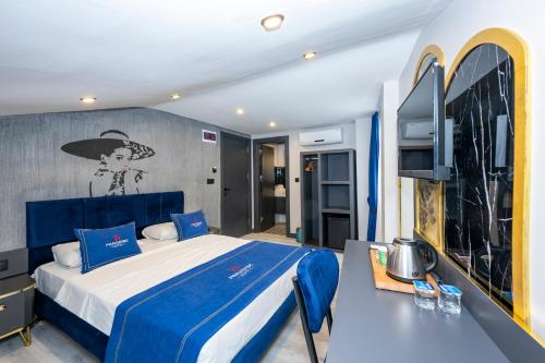 Un dormitorio con una cama azul y un televisor. en İstanbul Paradise Hotel, en Estambul