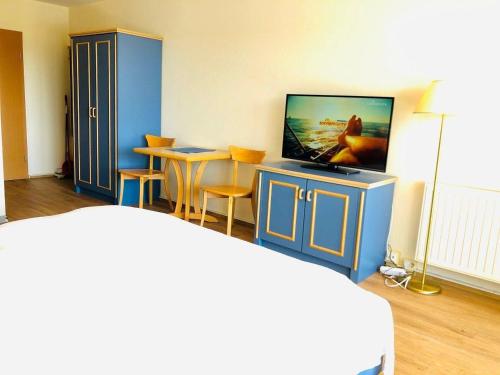 um quarto com uma televisão e uma mesa com cadeiras em Yachthafenresidenz-Wohnung-9207-895 em Kühlungsborn