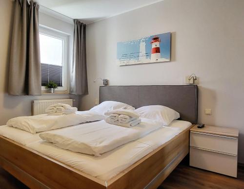 ein Schlafzimmer mit einem Bett und einem hellen Haus in der Unterkunft Yachthafenresidenz - Wohnung 7204 / 915 in Kühlungsborn