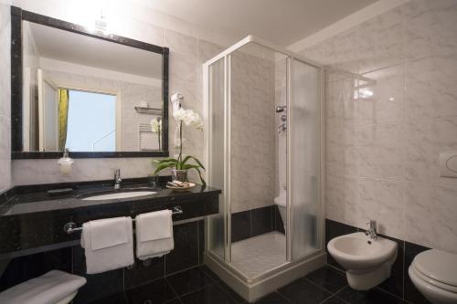 y baño con lavabo, ducha y aseo. en Villa Imperiale Hotel, en Spotorno