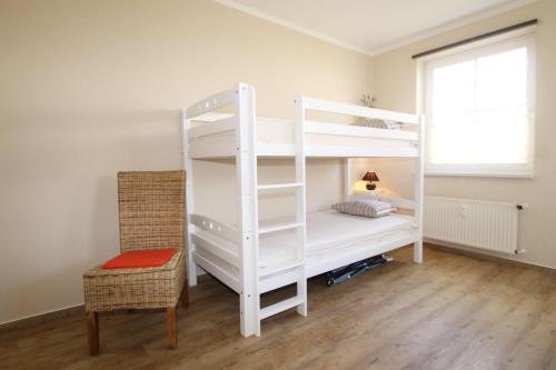 キュールングスボルンにあるStrandstrasse-43-Wohnung-4-9553のベッドルーム1室(二段ベッド2台、椅子付)